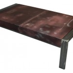Three quarter view of an industrial table made with the hood of a Chevrolet Chevelle 1980 car.