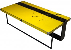 Three quarter view of an industrial table made with the trunk of an unknown yellow and black sport car.